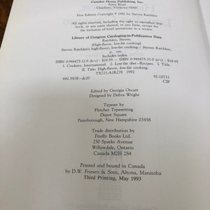 May include: A book cover with the title "High-flavor, Low-fat Cooking" by Steven Raichlen. The cover is white with black text and a black and white illustration of a chef. The book was published in 1992 by Camden House Publishing, Inc.