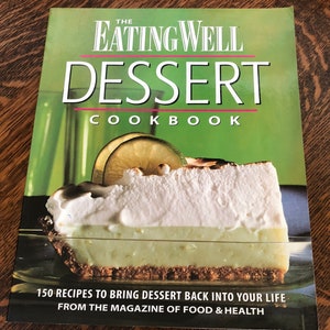 May include: The Eating Well Dessert Cookbook cover features a slice of key lime pie with a meringue topping, a lime wedge, and the title "Eating Well Dessert Cookbook" in bold, white letters on a green background. The text "150 Recipes to Bring Dessert Back Into Your Life" and "From the Magazine of Food & Health" are printed in black at the bottom.