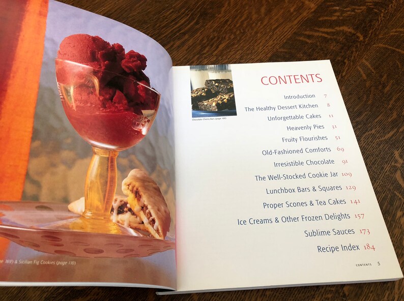 May include: A cookbook with a red and white cover and the word "CONTENTS" in large, red letters. The book features a variety of recipes, including desserts, cakes, pies, cookies, and more.
