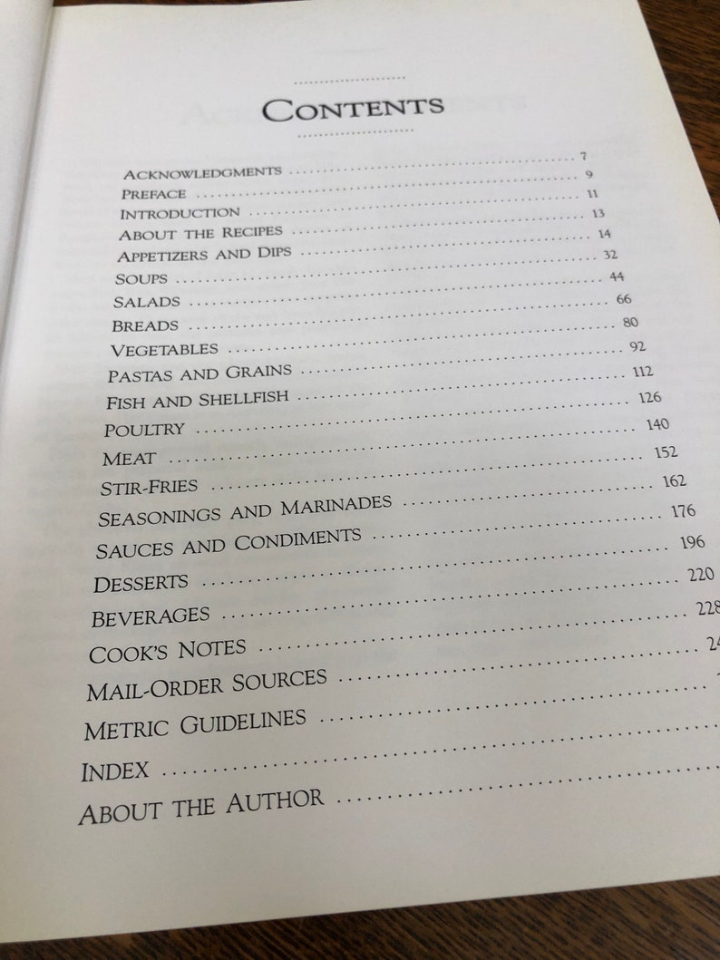 May include: A table of contents for a cookbook with page numbers for each section, including appetizers, soups, salads, breads, vegetables, pastas, fish, poultry, meat, stir-fries, seasonings, sauces, desserts, beverages, cook's notes, mail-order sources, metric guidelines, index, and about the author.