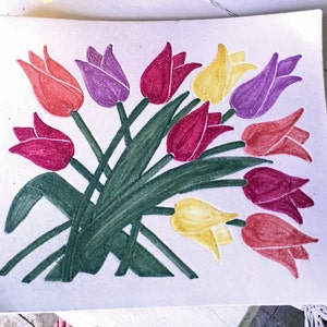 May include: A rectangular, off-white ceramic plate featuring a hand-painted bouquet of tulips. The tulips are in shades of red, purple, and yellow, with green stems and leaves. The plate is approximately 10 inches square.