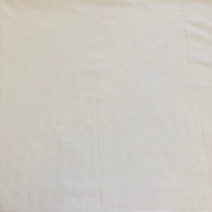 May include: A plain white fabric surface with a subtle texture.
