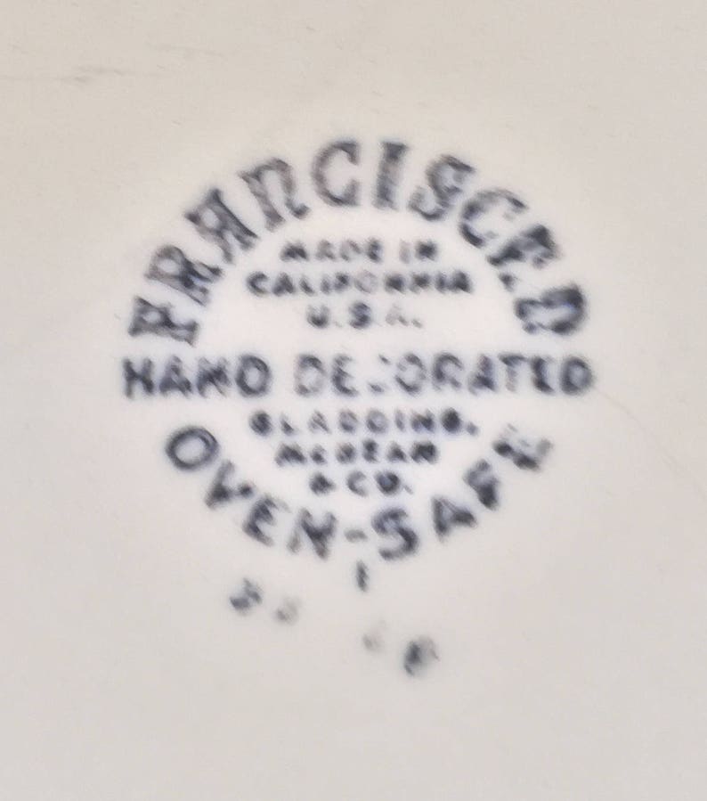 Pu&ograve; includere: Un piatto in ceramica bianca con un logo in bianco e nero che recita "FRANCISCO MADE IN CALIFORNIA U.S.A. HAND DECORATED GLADING-MCMEAN & CO. OVEN-SAFE".