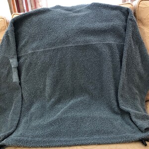May include: A blue fleece sweatshirt with a patch on the left sleeve.