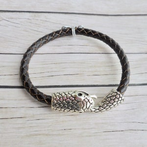 May include: A brown leather bracelet with a silver snake head clasp.