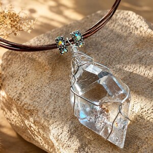 Handmade lodolite quartz necklace with a large faceted garden quartz pendant, silver wire wrapping, iridescent crystal beads and brown leather cords.