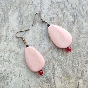 Op de afbeelding: Een set van drie keramische mokken met een gespikkelde, matte afwerking. De mokken zijn in de kleuren crème, lichtgrijs en donkergrijs. Elke mok heeft een eenvoudig, minimalistisch ontwerp en een afgeronde handgreep.