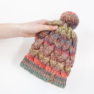 Bunte handgestrickte Zopfmütze. Damen dicke grobstrick Bommel Beanie. Roter Mix, Buntes Garn, gemasertes Winteraccessoire.