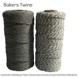 May include: Two spools of Bakers Twine. One is solid grey, the other is grey and white. The twine is tightly wound around a cardboard core. The text "Bakers Twine" is at the top of the image.