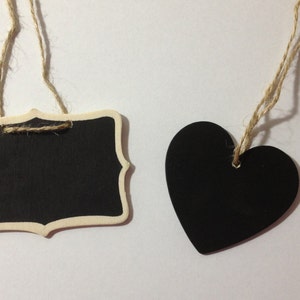 May include: Two black chalkboard signs with twine hanging loops. One sign is a rectangle with a decorative border and the other is a heart shape.