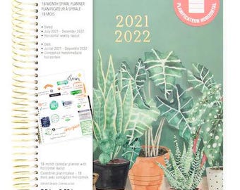 May include: A green and white 18-month spiral planner with a tropical plant design. The planner is 7.5 inches by 9.25 inches and has a gold wire binding.
