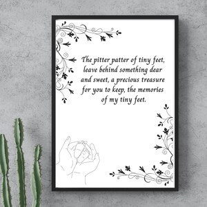 以下が含まれることがあります： 「The pitter patter of tiny feet, leave behind something dear and sweet, a precious treasure for you to keep, the memories of my tiny feet.」というテキストが入った黒いフレームのプリント。プリントには、赤ちゃんの足を抱える手の線画も描かれています。