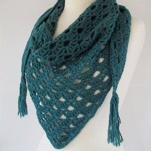 May include: Teal crochet shawl with fringe tassels. The shawl is made with a delicate openwork pattern.