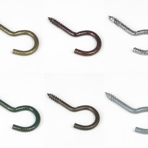 May include: Six screw-in hooks in different finishes: gold, bronze, silver, green, black, and gray. Each hook has a textured finish.