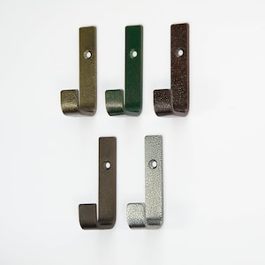 Pode incluir: Cinco ganchos de metal em diferentes cores: dourado, verde, castanho, bronze e prata. Os ganchos são todos do mesmo tamanho e forma, com um design simples em forma de J.