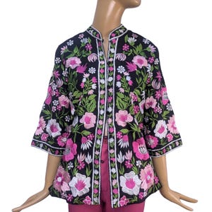 May include: Black jacket with a floral embroidery design featuring pink, white, and green flowers. The jacket has a mandarin collar, three-quarter sleeves, and white trim. The embroidery is detailed and covers the entire jacket.