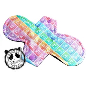 May include: A reusable cloth menstrual pad with a rainbow pattern featuring the periodic table of elements. The pad has a black border and purple snaps.