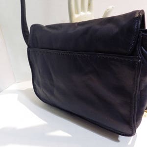May include: A black leather shoulder bag with gold hardware. The bag has a flap closure and a single strap.