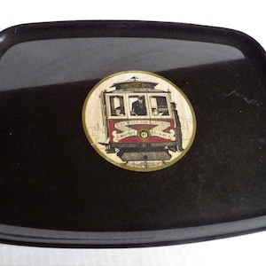 May include: Black plastic tray with a gold and red circular design featuring a vintage streetcar with the text "Van Ness Ave and California Street -  L.M.  Street Railway"