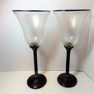 May include: Two frosted glass wine glasses with black twisted stems and black bases.