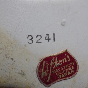 May include: Close-up of a white ceramic surface with the number "3241" printed in black. A red and gold "Lefton's" sticker is affixed to the surface, with text indicating it is a U.S. patent and exclusive product from Japan.