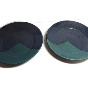 Puede incluir: Dos platos de cerámica con un esmalte azul y verde. Los platos tienen un diseño sencillo con una línea curva que separa los dos colores.