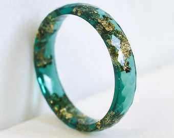 Anel Empilhável de Esmeralda – Anel facetado em resina verde com flocos de ouro, aro fino e minimalista.