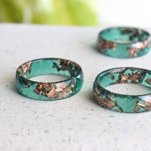 Flat lay of the jade ring styled with minimal gold jewelry and soft textures for a romantic look.