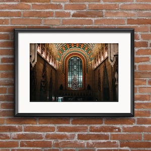 May include: A framed photograph of a grand building interior with a large arched window and a Christmas tree in the center. The ceiling is decorated with colorful geometric patterns.