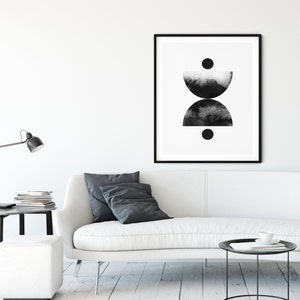 May include: Black and white abstract art print with two half circles and two circles. The print is framed in a black frame and hanging on a white wall.