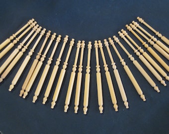 May include: A set of 20 wooden knitting needles, all the same size and colour. The needles are arranged in a semi-circle shape, with the tips pointing towards the centre.