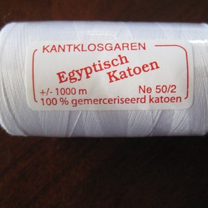 May include: A white spool of thread labeled "KANTKLOSGAREN Egyptisch Katoen +/- 1000 m 100% gemerceriseerd katoen Ne 50/2"