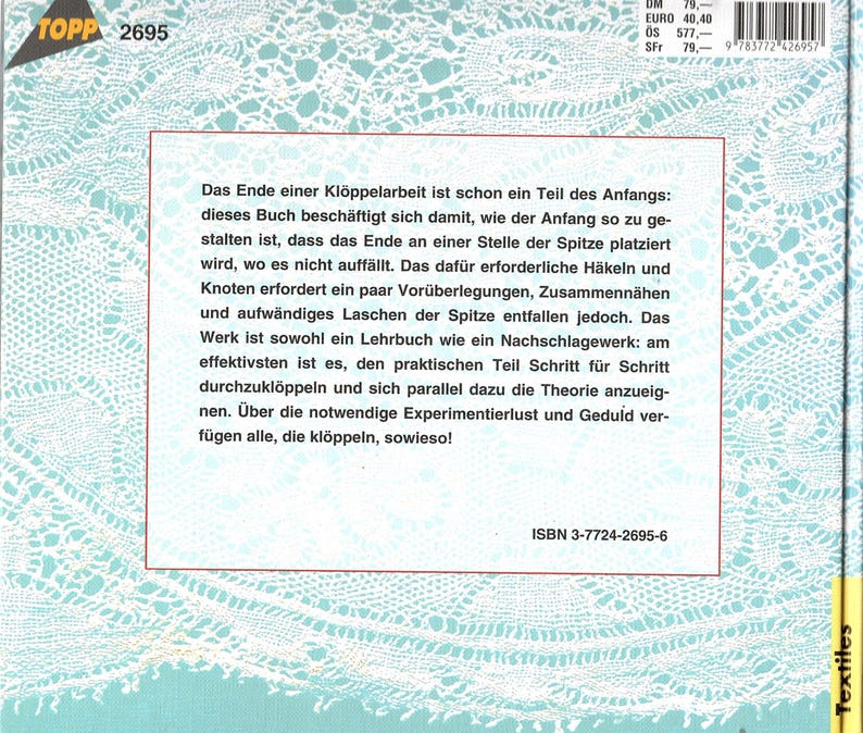 May include: A book cover with a white lace pattern and text in German. The book is titled "TOPP 2695" and includes the ISBN 3-7724-2695-6. The cover has a red border and a price tag.