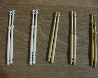 May include: Five pairs of wooden bobbins for lace making. The bobbins are white and natural wood colour. The bobbins have a rounded top and a pointed bottom.