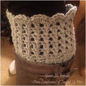 May include: Gray crocheted boot cuffs with a scalloped edge. The cuffs are worn on brown leather boots. The text "Glacier Blu Boutique - Photo Compliments of Tangled Up Mess" is visible at the bottom of the image.
