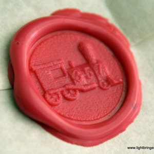 May include: A red wax seal with a detailed image of a train engine. The seal is on a white background.
