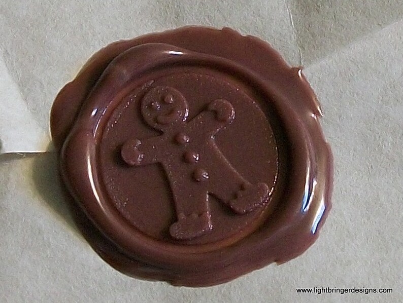 May include: A brown wax seal with a gingerbread man design.