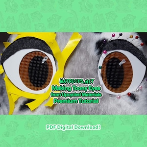 May include: Close-up of a furry, grey and white animal head with two large, brown, toony eyes. The eyes are made from upcycled materials and are pinned to the head with colourful pins. The text "MATRICES.NET Making Toony Eyes from Upcycled Materials Premium Tutorial PDF Digital Download!" is visible below the eyes.