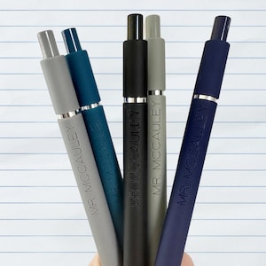 May include: Five pens with different colored bodies and silver accents. Each pen has the text "MR. MCCAULEY" printed on the side.