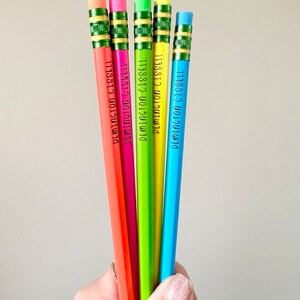 May include: Five colorful pencils with green erasers and the name "DEMINGTON CISSELL" printed on each pencil.