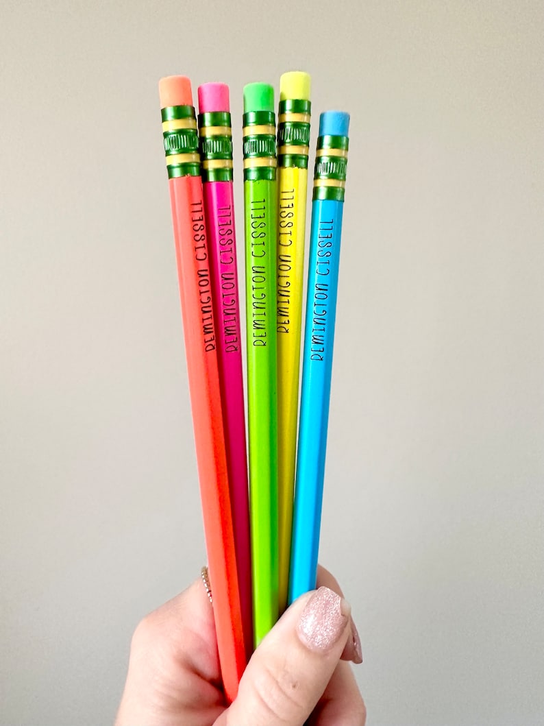 May include: Five colorful pencils with green erasers and the name "DEMINGTON CISSELL" printed on each pencil.