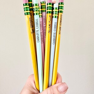 May include: A bunch of yellow pencils with different colored erasers and personalized names, including "Mrs. Millers Class", "Charlotte Cissell", and "Rylan Edwards".