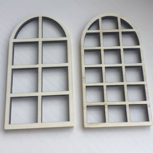 Könnte beinhalten: Zwei hölzerne Bogenfensterrahmen mit schwarzen Gittermustern. Der Rahmen links hat ein einfaches Gittermuster, während der Rahmen rechts ein komplexeres Gittermuster hat.