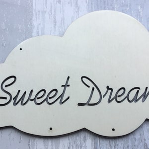 May include: White wooden cloud-shaped sign with the text "Sweet Dreams" in black cursive lettering.