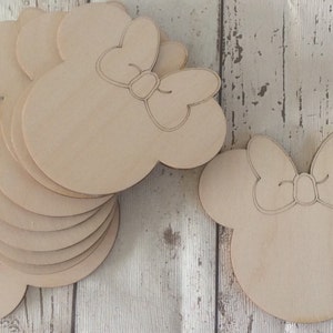 Puede incluir: Un conjunto de diez recortes de madera sin terminar en forma de cabeza de ratón de dibujos animados con un lazo. Los recortes miden aproximadamente 10 cm de alto y 7,5 cm de ancho.