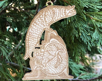 Könnte beinhalten: Ein hölzerner Weihnachtsschmuck mit einem stilisierten Drachendesign. Der hellbraune Schmuck weist aufwendige geätzte Details auf, darunter Schuppen und ein eingerollter Schwanz. Er hängt an einer grünen Schnur, ideal für die Weihnachtsdekoration.
