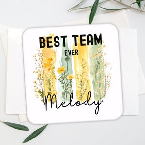 May include: White coaster with a floral design and the text "Best Team Ever Melody".