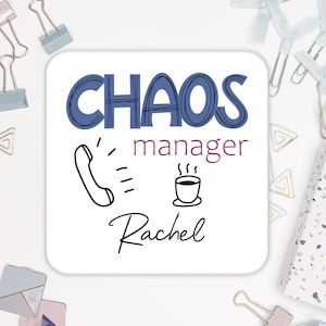 May include: White square coaster with the text "CHAOS manager" in blue and "Rachel" in burgundy. A black and white illustration of a phone and a steaming cup of coffee are below the text.
