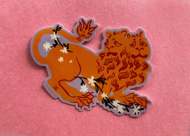 May include: A sticker of a two-headed orange lion with a purple background and white flowers. The lion has a mane of orange flames.