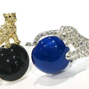 Lotto vintage di 2 spille a forma di leopardo con strass Napier appollaiato su una sfera di smalto blu e nero